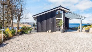 A modern black building with a large window and a covered patio area. - 5 Star Holiday Home in Logstrup (Logstrup)
