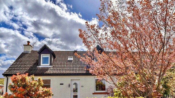 A house with a tiled roof, a small window, and a door. - The perfect location to explore the Highlands. (Nairn)