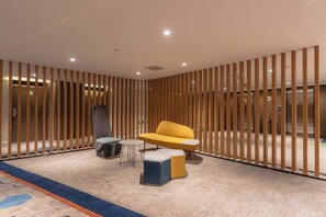 Un intérieur moderne comprenant un coin salon, une petite table et un mur décoratif.