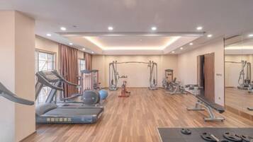 Ein Fitnessstudio mit Laufbändern, Crosstrainern und Gewichten.