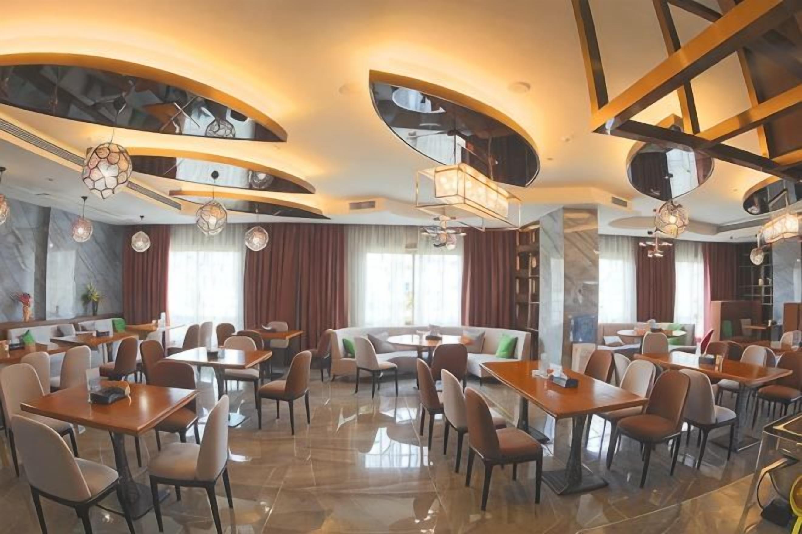 A spacious restaurant with multiple dining areas, including a central seating area and several smaller tables.