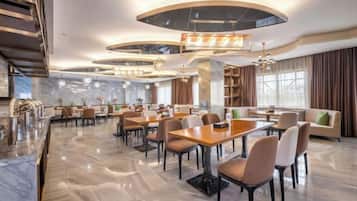 Eine großzügige Hotelhalle mit verschiedenen Sitzbereichen, Marmorboden und modernen Leuchten.