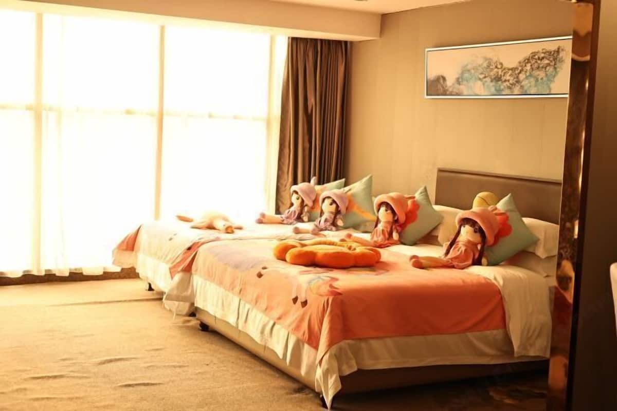 Une chambre d’hôtel avec un grand lit, plusieurs oreillers, une tête de lit et un tableau au mur.
