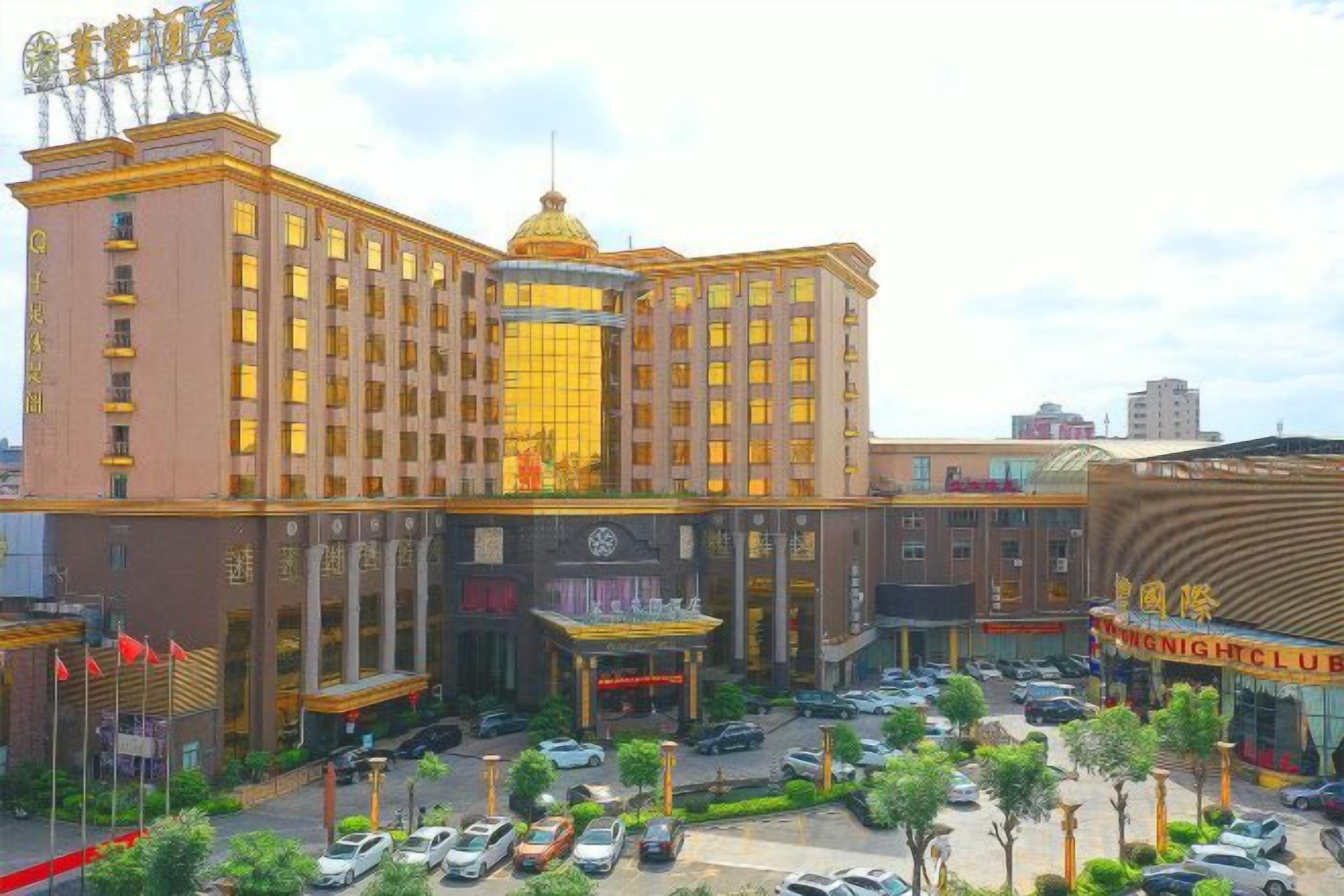 A multi-story hotel with a central courtyard, a casino, and a large parking lot.