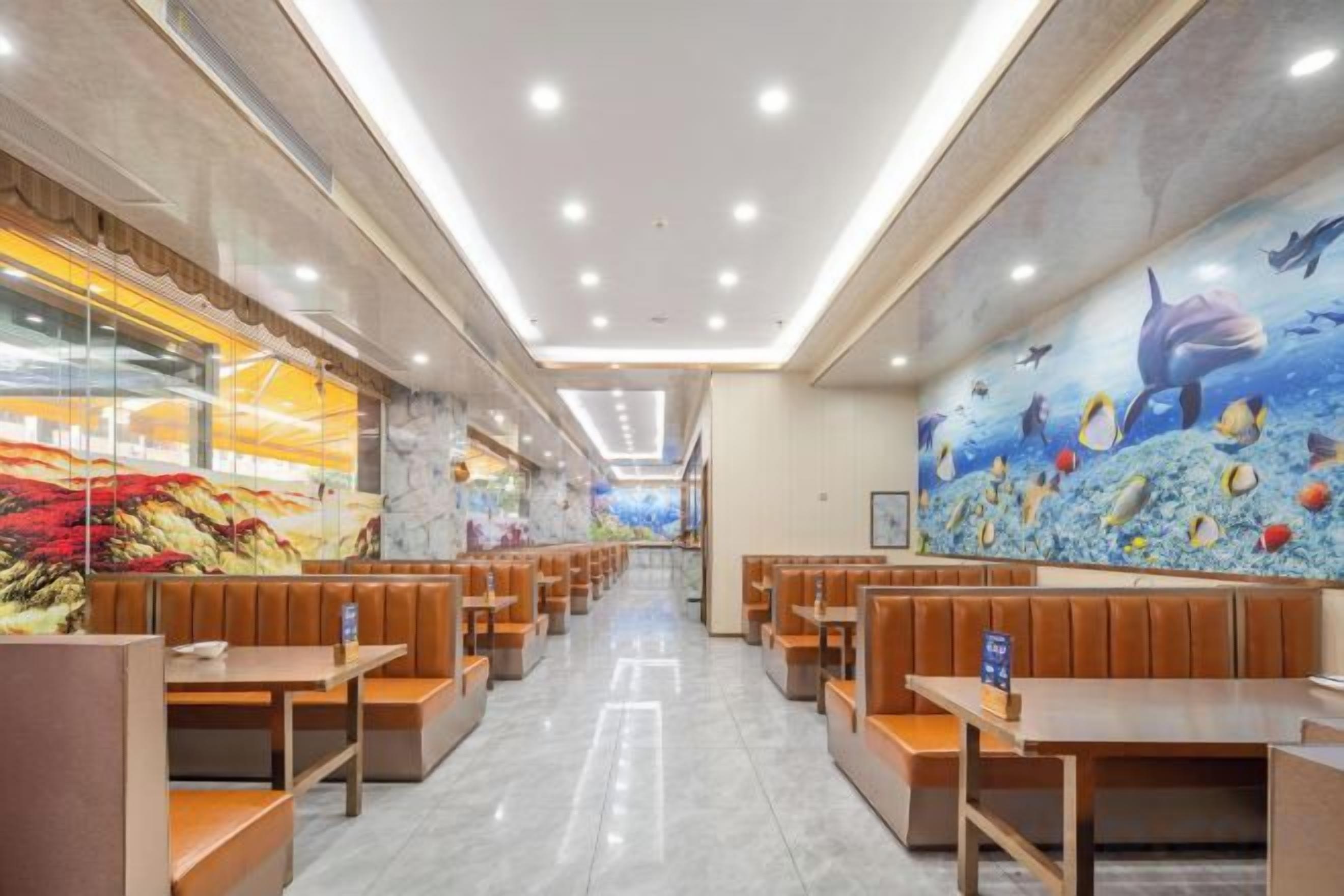 A restaurant with booths and tables, a mural of underwater scene, and a glass wall on one side.