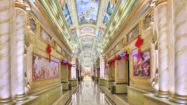A grand hallway with marble columns, ornate ceiling artwork, and framed pictures on the walls. - Ye Feng Garden Hotel (Dongguan)