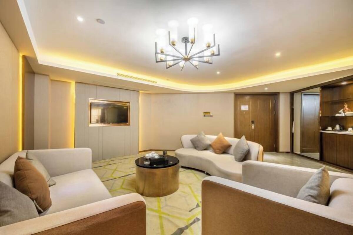 Un salon moderne avec une table basse ronde, deux canapés et un lustre.