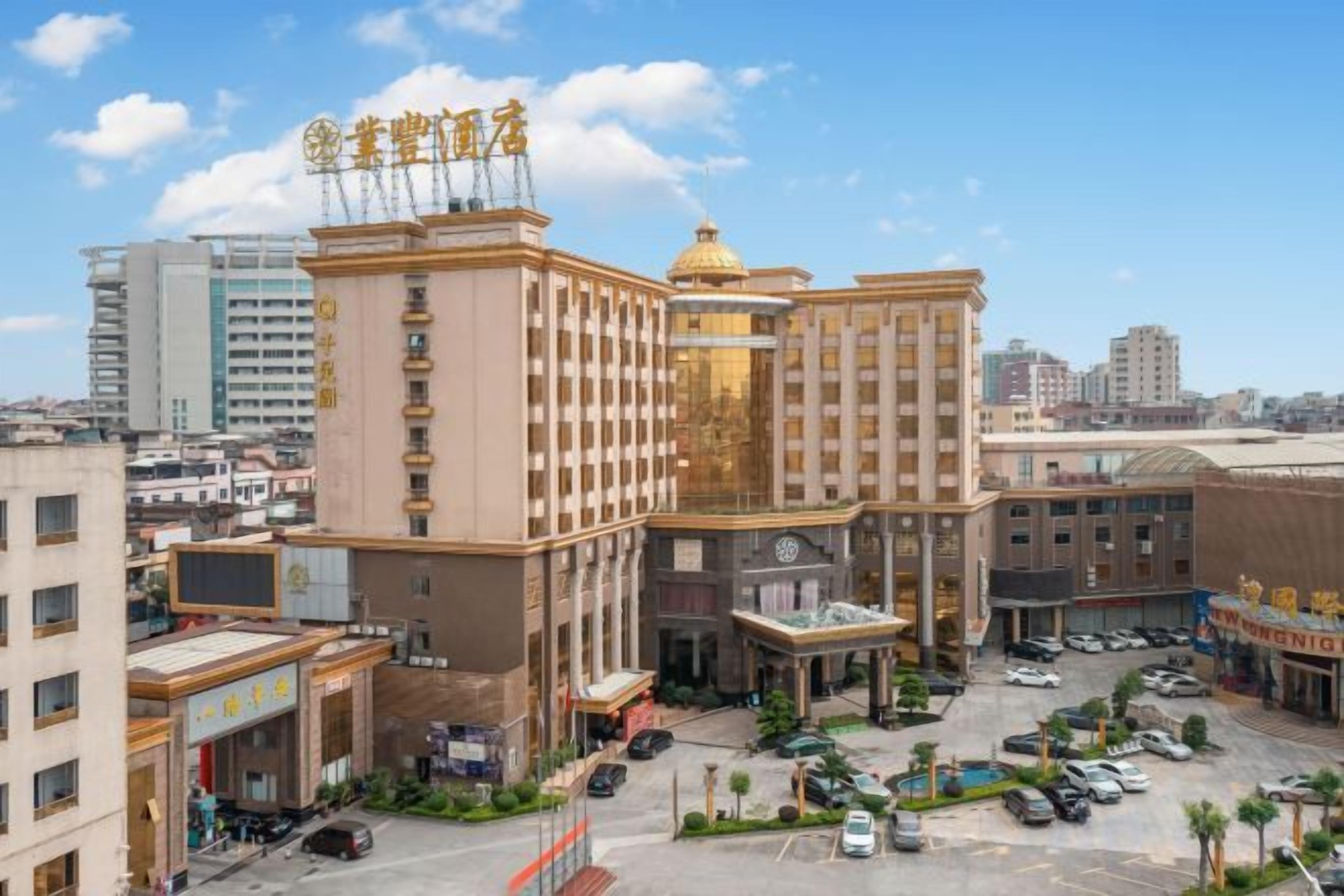 A hotel with multiple floors, a parking area, and a view of the surrounding cityscape.
