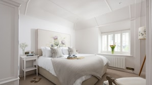 A bedroom with a bed, bedside table, and a window with a view.