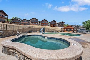 Un resort con varias edificaciones, un jacuzzi y una zona de piscina.