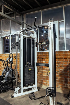 Een sportschool met een bakstenen muur en grote ramen.