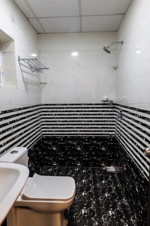 Een badkamer met toilet, wastafel en douche.