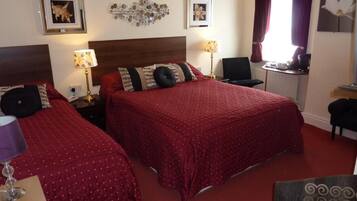 A hotel room with two beds, a desk, and a chair.
