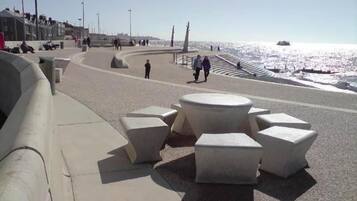 A coastal promenade with benches and a curved walkway.