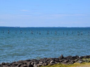 A calm body of water with a rocky shoreline and a distant horizon. - 8 Person Holiday Home in Nakskov (Nakskov)