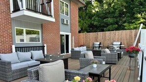A patio with outdoor furniture, a grill, and a wooden deck.