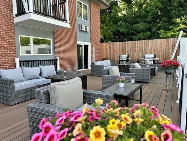 A patio with outdoor furniture, a grill, and a wooden deck.