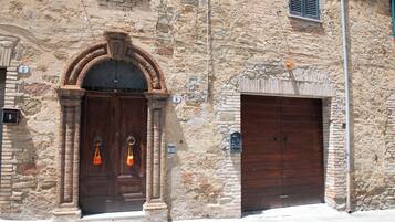 A stone building with two wooden doors, one with a semi-circular arch and the other with a rectangular design.