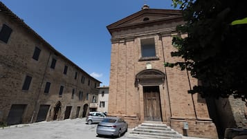 A historic building with a large wooden door, a bell tower, and a staircase leading to the entrance.