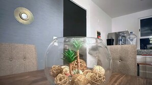 Een transparante glazen schaal met decoratieve objecten op een houten tafel in een moderne keuken.