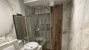 A modern bathroom with a glass-enclosed shower, a white sink, and a toilet. - Superb 1-bedroom apartment in Tiranë (Tiranë)