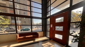 A room with large windows, a bench, and a tiled floor. - Oceana Suites Vista Parque (Santiago)