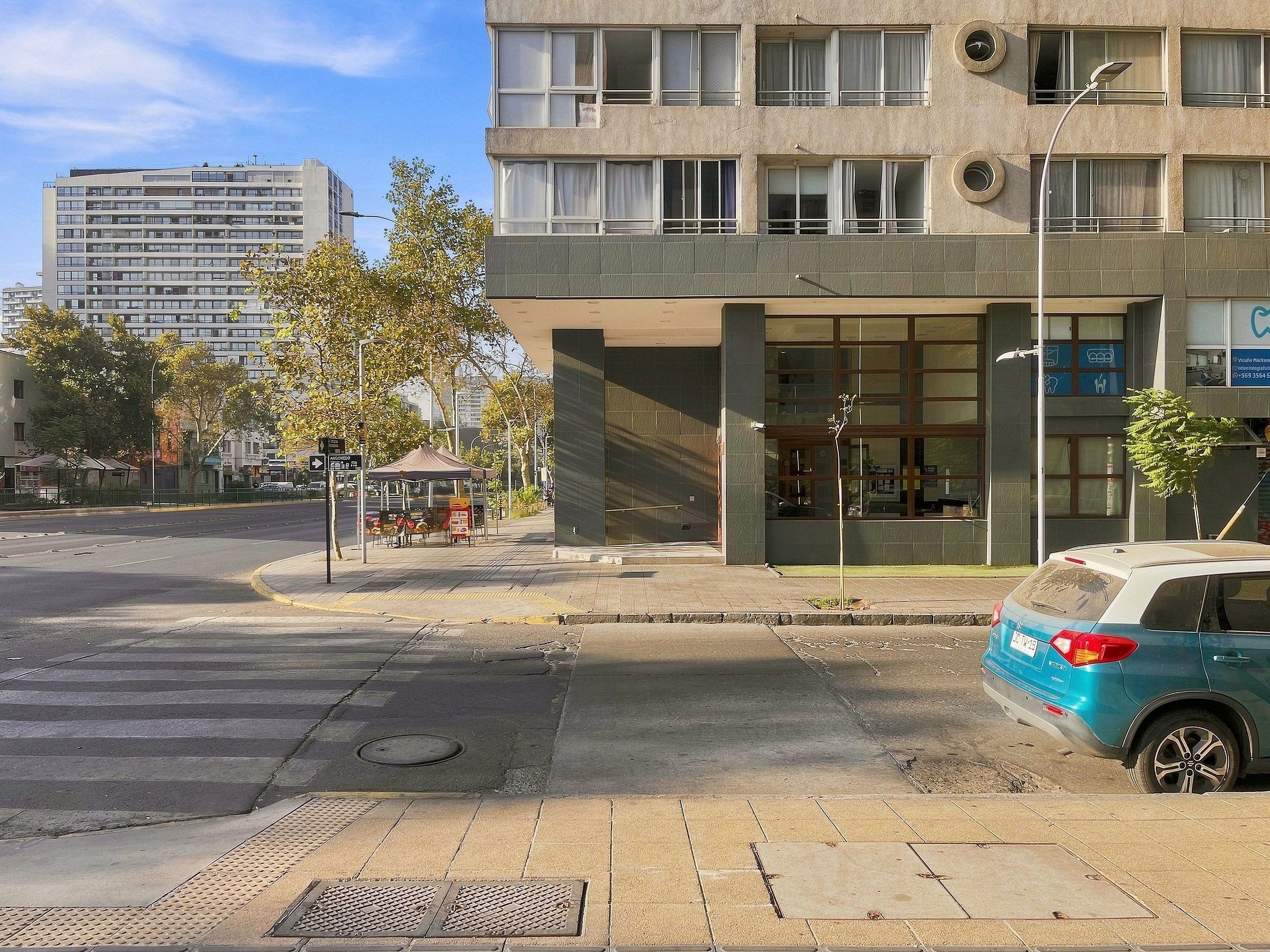 A multi-story building with a ground-level entrance, large windows, and a visible signboard.