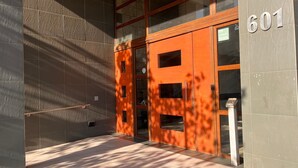 A building entrance with a number '601' sign, a glass door, and a metal handrail. - Oceana Suites Vista Parque (Santiago)