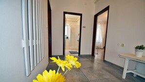 A hallway with a bench, a potted plant, and a door leading to another room. - Apartment in Valbandon Near Adriatic Beach (Fazana)