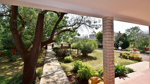 A covered outdoor area with a pathway, trees, and a brick pillar. - Apartment in Valbandon Near Adriatic Beach (Fazana)