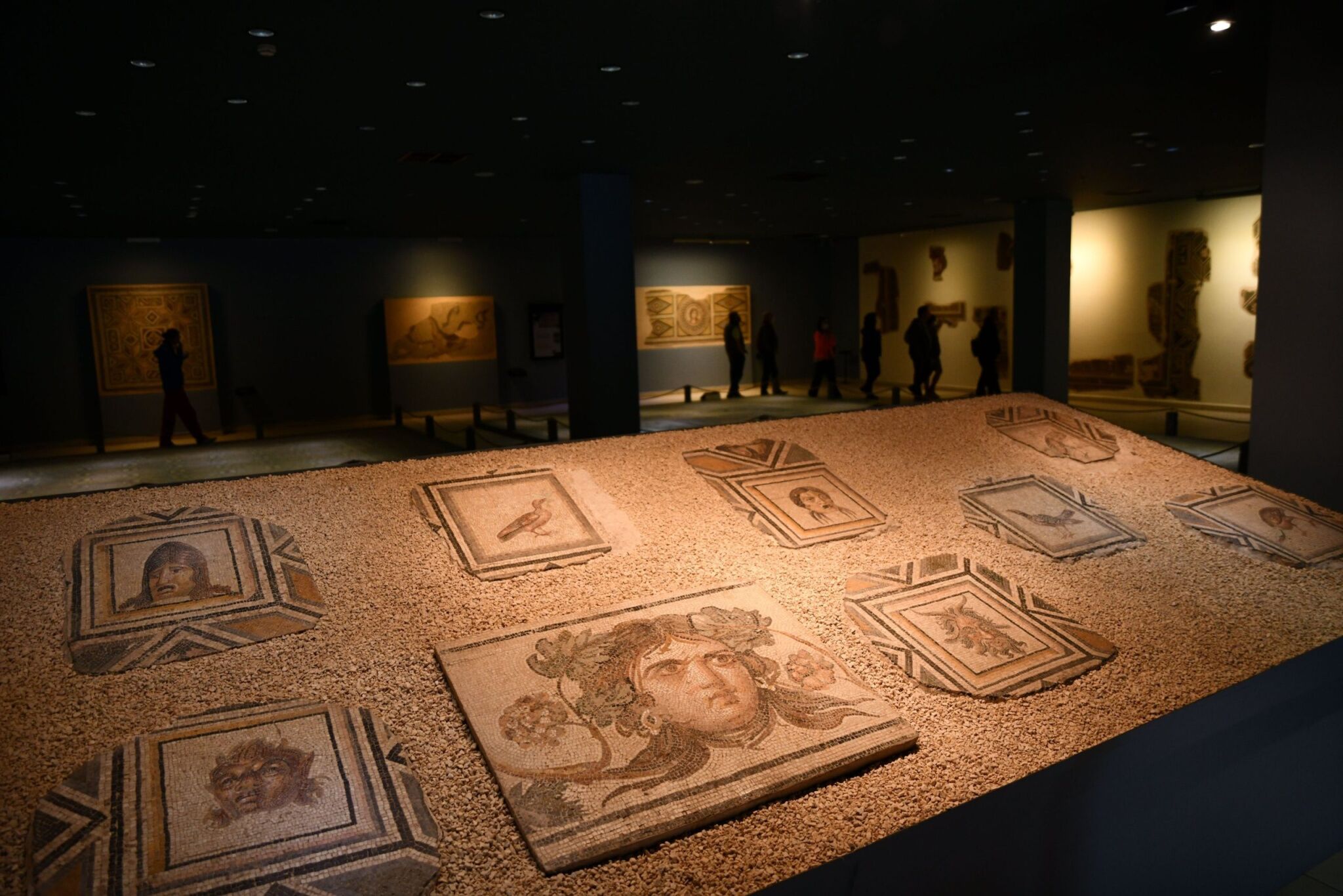 Una exhibición de museo con artefactos antiguos y mosaicos.
