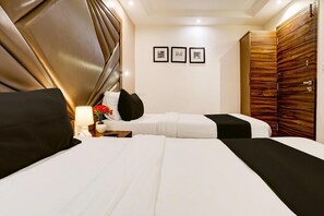 A hotel room with a large bed, a smaller bed, and a wardrobe. There are three framed pictures on the wall. - Comfortable Stays at Mumbai Central (Mumbai)