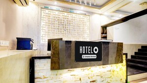 Una mesa de recepción con un cartel que dice "HOTELO" y un cartel direccional para "RECEPTION" y "PRIMER PISO".