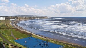 Eine Küstenansicht mit einem Spielplatz und Strand.