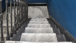 Eine Treppe mit Metallgeländern und einer blauen Wand.