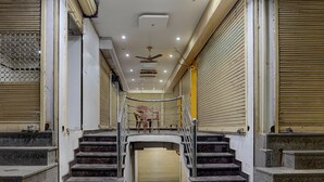 A staircase leading to a closed door with a metal railing, a ceiling fan, and recessed lighting.