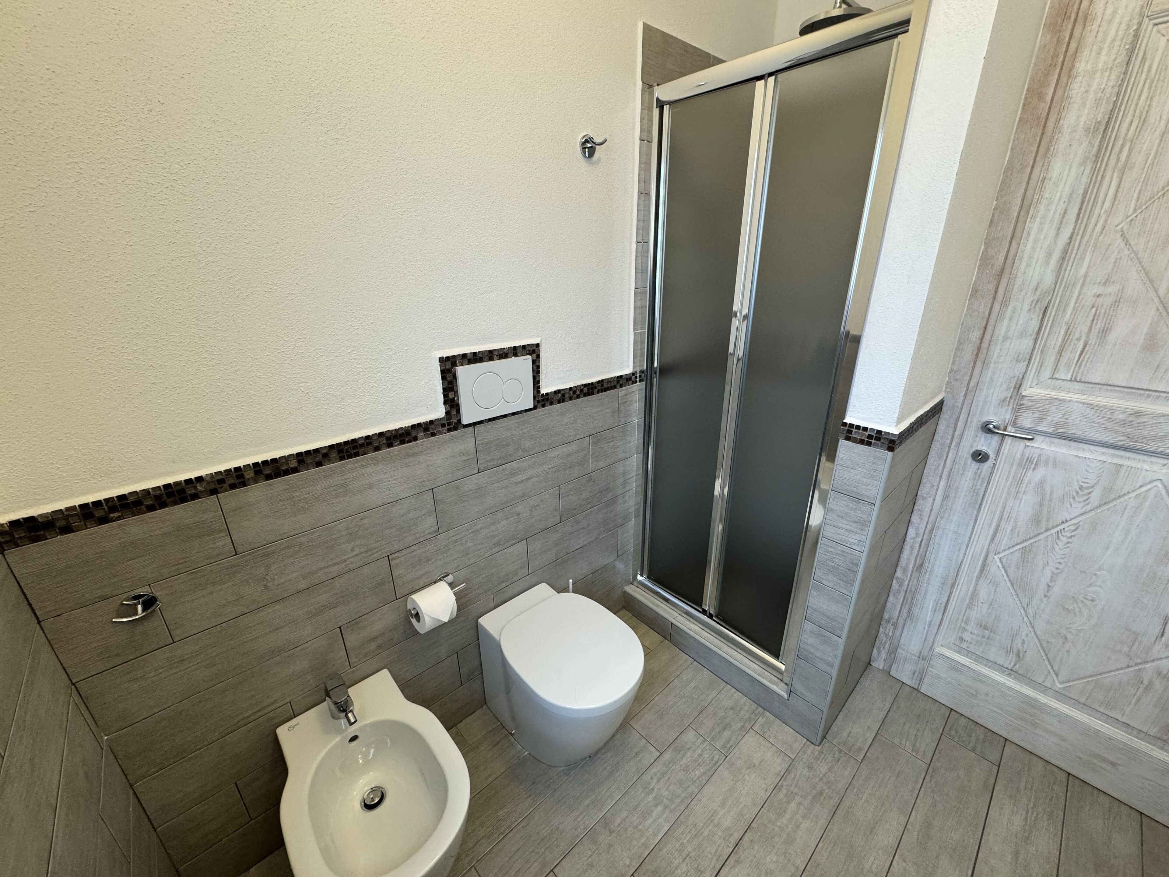 Ein Badezimmer mit Dusche, Toilette und Waschbecken.