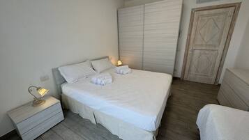 A bedroom with a bed, nightstand, and wardrobe.