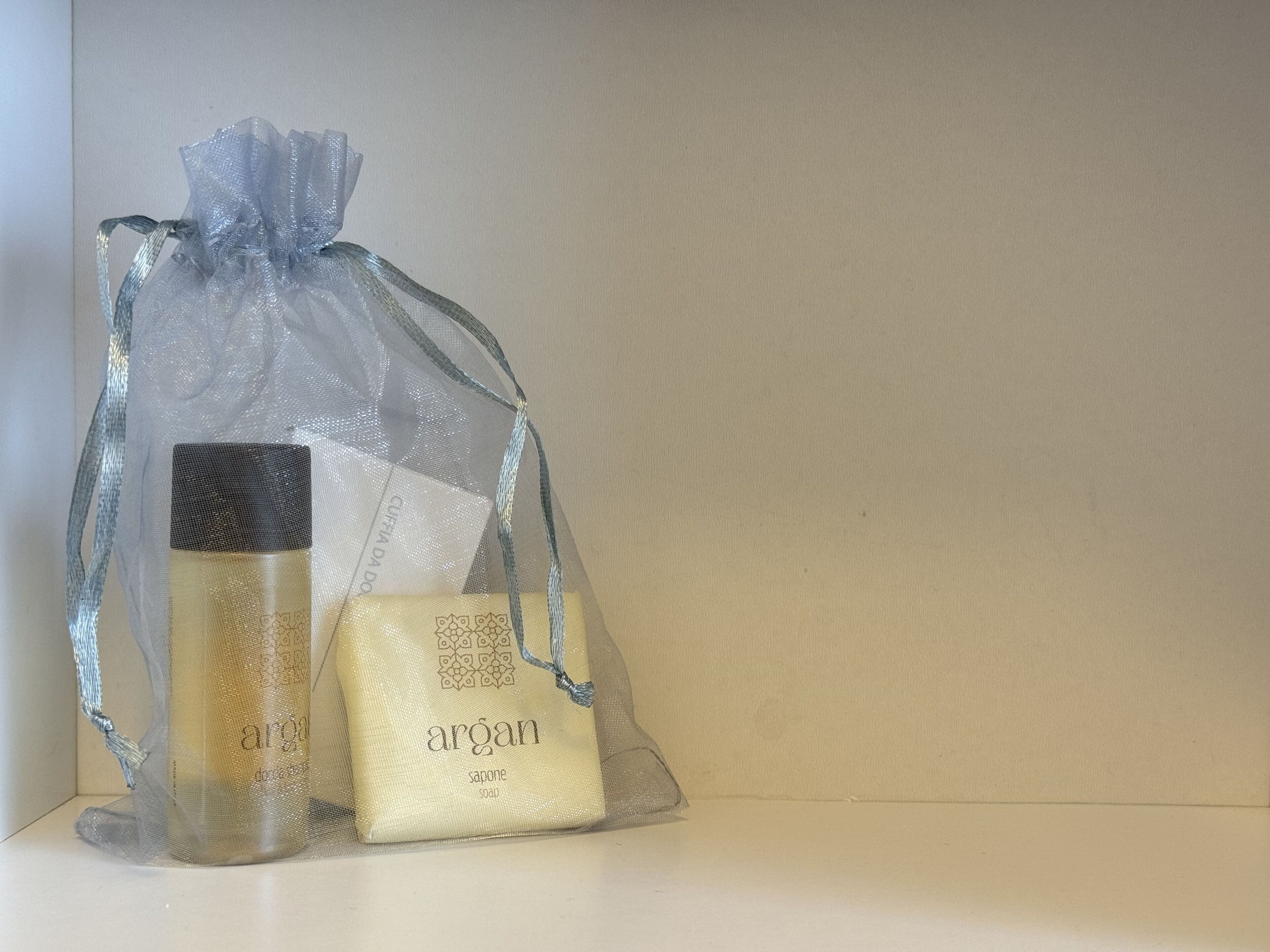 Un sac cadeau transparent contenant une bouteille et un savon.