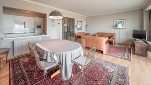A modern living room with a dining area, a kitchen, and a television. - Apartment in Knokke-heist by the Seafront (Knokke-Heist)