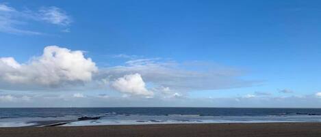 A beach with a clear sky and calm sea.