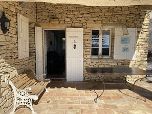 A stone building with a bench, a table, and a door leading inside. - La Souvenance, listed villa, panoramic view (Lagnes)