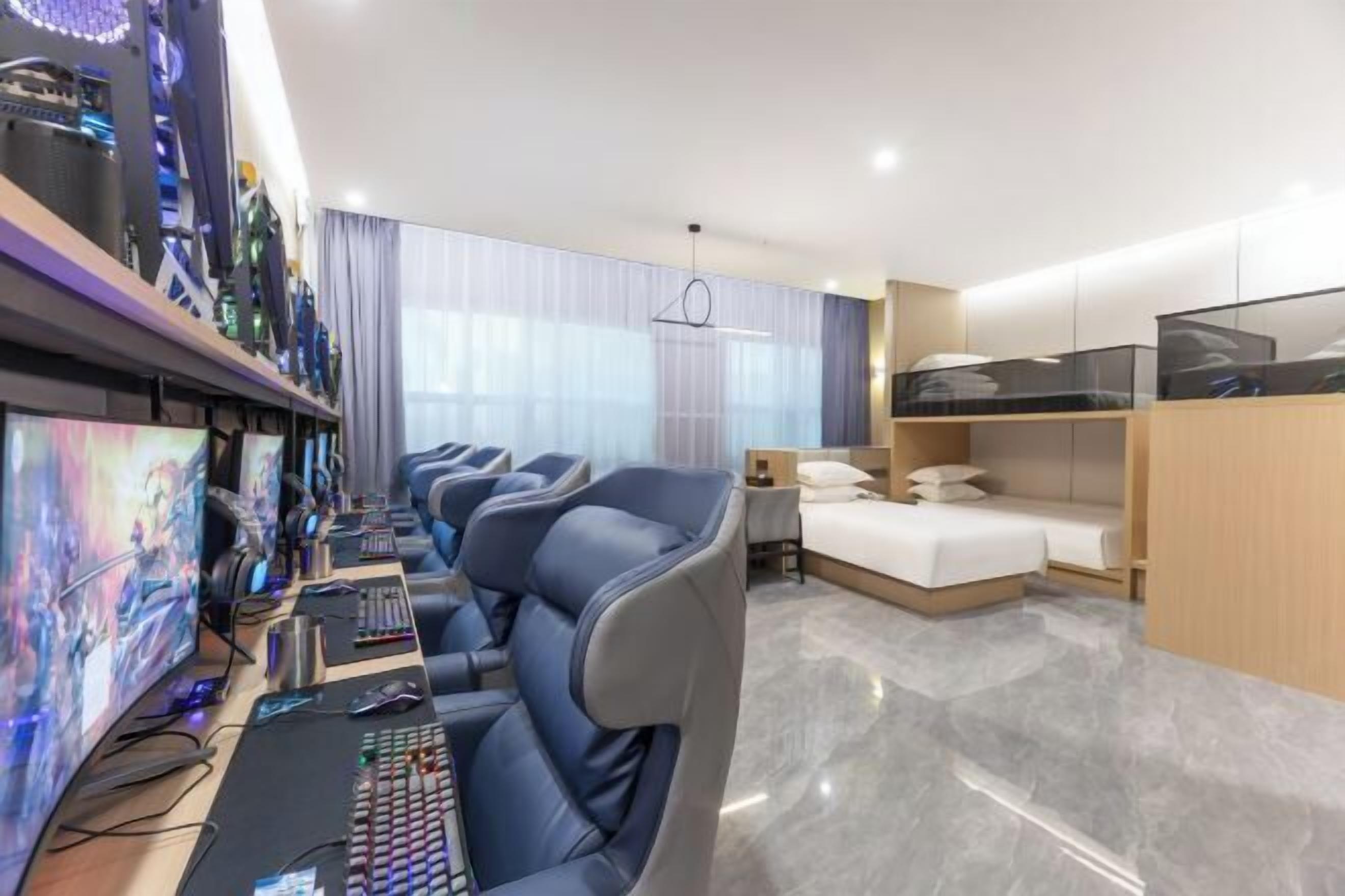 Ein modernes Hotelzimmer mit Gaming-Einrichtung, einem Bett und einem Fernseher.
