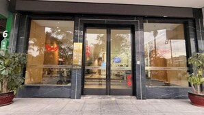 A hotel entrance with a glass door and a number '6' sign. - Crossing E-sports Hotel (Wenzhou)