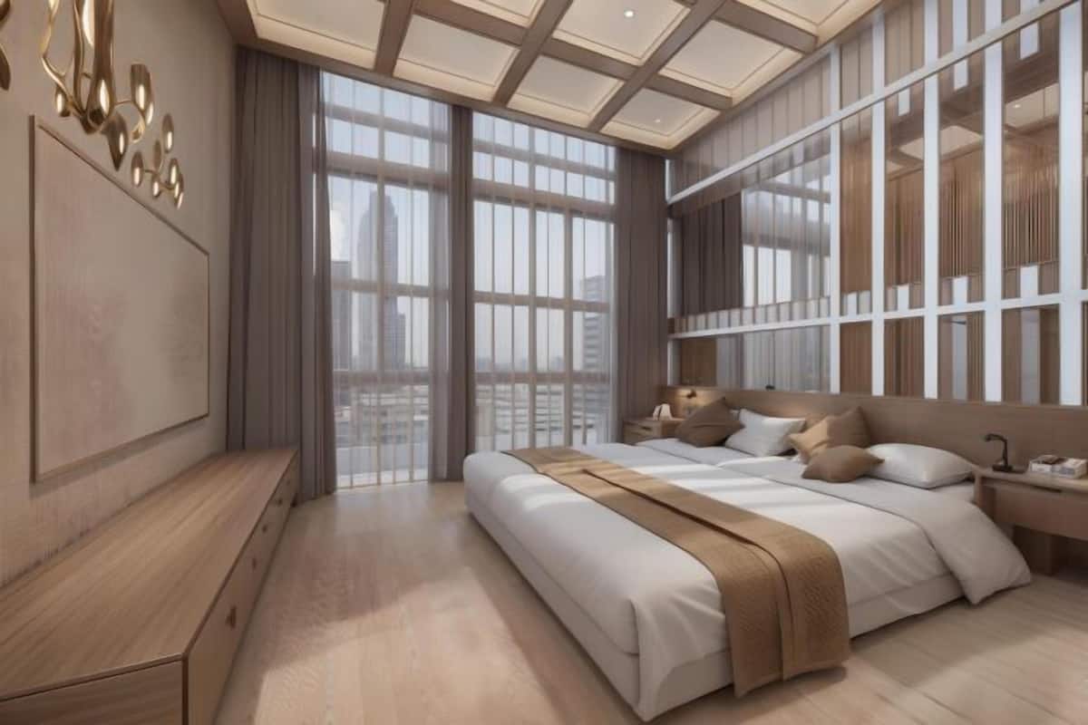 Un dormitorio moderno con una cama grande, una mesita de noche y vistas a la ciudad a través de amplios ventanales.