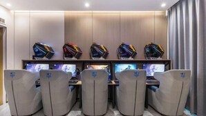 A gaming room with five gaming chairs, a row of gaming PCs, and a large window with curtains. - Crossing E-sports Hotel (Wenzhou)