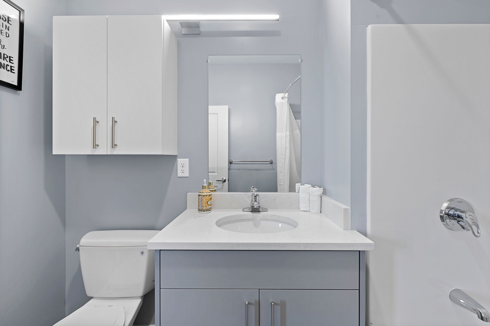 Ein modernes Badezimmer mit Waschbecken, Waschtisch und Toilette, alles in Weiß.