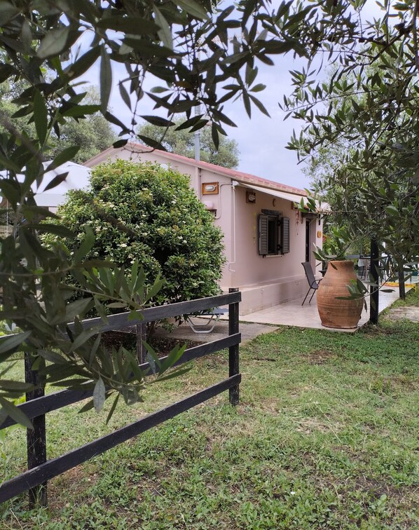 A house with a garden, a wooden fence, and a large pot.