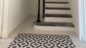 Een trap met houten leuning en een zwarte balustrade, leidend naar een verdieping.