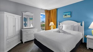 Habitación de hotel con una cama grande, un armario, un espejo y vista a la ciudad.